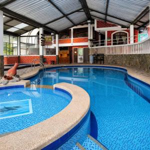 a large swimming pool in a large building at Hostería Agoyán Deluxe in Ulba