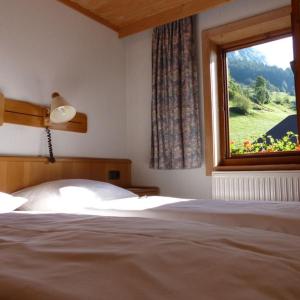 a bedroom with a bed and a large window at Hotel Gasthof Islitzer in Prägraten