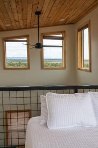 a bedroom with a white bed with two windows at Tiny Cabin #4 at The Cedars in Kanab