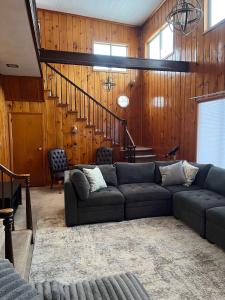 a living room with a couch and wooden walls at Cozy Waterfront Cottage in Beaverton