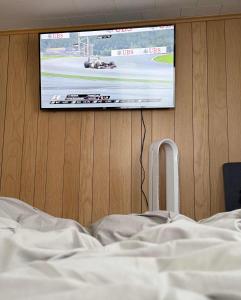 a bedroom with a tv on a wall with a bed at Cozy Waterfront Cottage in Beaverton +21 photos
