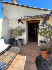 a patio with potted trees in pots next to a building at La Parenthèse in Bourg-Saint-Andéol