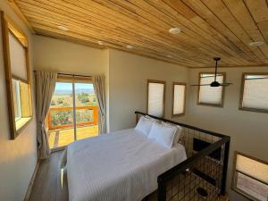 a bedroom with a bed and a large window at Tiny Cabin #5 at The Cedars in Kanab