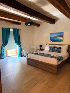 a bedroom with a large bed with blue curtains at Soleil B&B Gozo in Għarb +81 photos