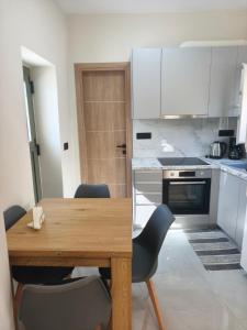a kitchen with a wooden table and chairs at Agapi's Nest in Agápi