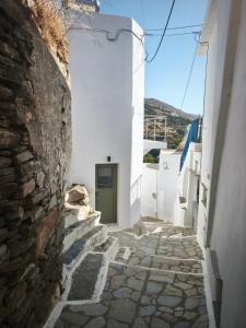 a narrow alley with a green door in a white building at Agapi's Nest in Agápi