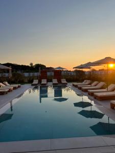 a swimming pool with lounge chairs and umbrellas at Velipoja Residences in Velipojë