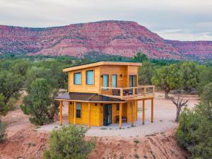 a house in the middle of a field with a mountain at Tiny Cabin #6 at The Cedars in Kanab