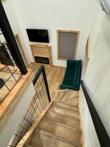 a staircase with a green chair and a television at Tiny Cabin #7 at The Cedars in Kanab