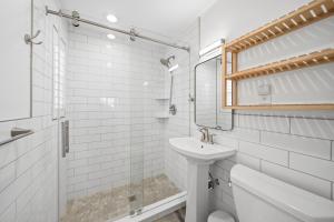 a white bathroom with a sink and a mirror at Inn on the Beach in St. Pete Beach