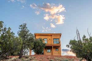 a house on top of a hill with trees at Tiny Cabin #7 at The Cedars in Kanab