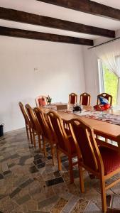 a dining room with a long table and chairs at Vraja din deal in Domneşti