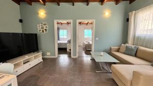 a living room with a couch and a flat screen tv at Finca House by Fataga Maspalomas in San Bartolomé