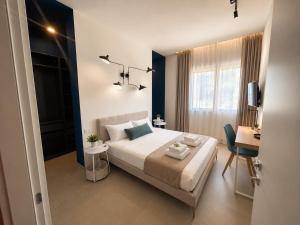 a bedroom with a bed and a desk and a window at Casa Pelagos in Brindisi