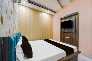 a bedroom with a bed and a flat screen tv at Hotel O Rameshwar Inn in Prayagraj