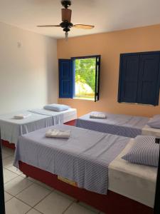 a room with two beds and a window at Pousada da Cida in Lençóis