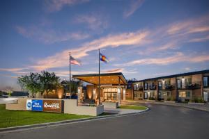 a hotel with two flags in front of a building at Best Western Denver East in Denver