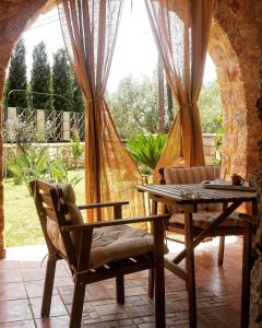 una sala da pranzo con tavolo, sedie e finestra di Niko's Stone Guest House a Plitra