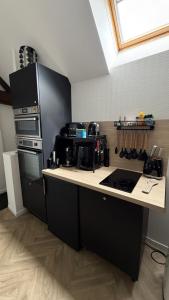 a kitchen with a black refrigerator and a counter at Le Pétillant in Cramant +6 photos