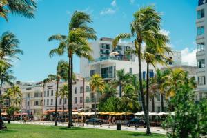 a building with palm trees in front of it at Iberostar Waves Miami Beach in Miami Beach