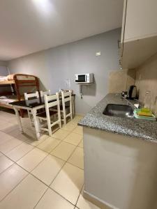 a kitchen with a sink and a table in a room at Apartamentos El Fortín in San Salvador de Jujuy