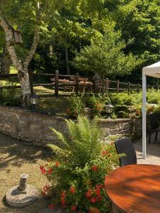 a table and chairs in a garden with a fence at Albergo Ristorante Lo Scoiattolo in Campigna +4 photos