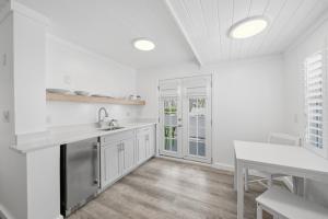 a white kitchen with a sink and a counter at Inn on the Beach in St. Pete Beach +16 photos