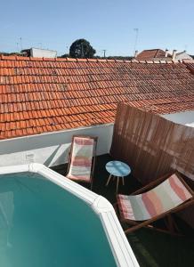 two chairs and a table next to a swimming pool at Casa Da Aldeia in Alcácer do Sal