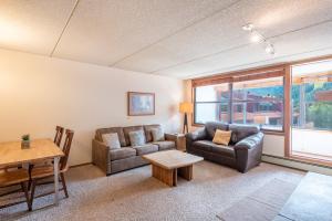 a living room with two couches and a table at Village Square West 353 in Copper Mountain +21 photos