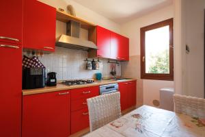a red kitchen with red cabinets and a table at Casa Stella Marina in Cervia
