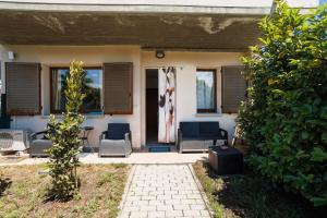a house with chairs and a flag on the door at Casa Stella Marina in Cervia +7 photos