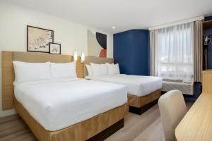 a hotel room with two beds and a window at Spark by Hilton Edmundston in Edmundston