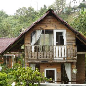 a house with a balcony on the side of it at Nhà Để Chill Homestay in Da Lat