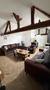 a living room with couches and a coffee table at Le Pétillant in Cramant