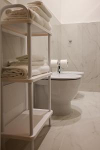 a white bathroom with a towel rack next to a toilet at B&B Salerno Stay in Salerno +26 photos