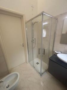 a bathroom with a glass shower and a sink at La Dimora del Duomo in LʼAquila +26 photos