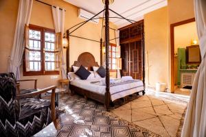 a bedroom with a canopy bed in a room at Daba Riads in Marrakesh
