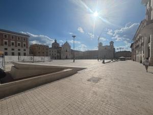 a city street with buildings and the sun in the sky at La Dimora del Duomo in LʼAquila