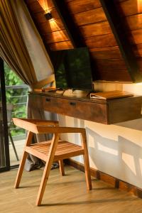 a desk with a chair next to a table at Forest Face Lodge in Gurudeniya