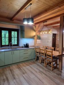 a kitchen with a wooden floor and a table and chairs at Gajówka nad Serwami in Mołowiste
