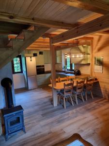 a kitchen and dining room with a table and a stove at Gajówka nad Serwami in Mołowiste +13 photos
