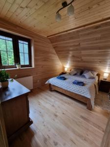 a bedroom with a bed in a wooden cabin at Gajówka nad Serwami in Mołowiste