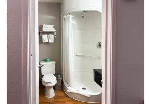 a bathroom with a shower with a toilet and a sink at Studio 6 Pecos Texas in Pecos +17 photos