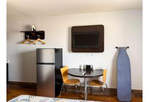 a room with a table and a refrigerator and a tv at Studio 6 Pecos Texas in Pecos