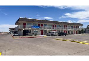 a building with a car parked in a parking lot at Studio 6 Pecos Texas in Pecos