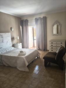 a bedroom with a bed and a chair and a dresser at La Maison dos Prazeres in Portimão +75 photos