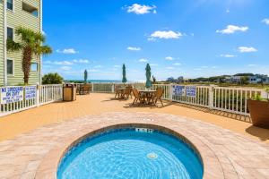 a pool on the deck of a house with a table and chairs at Sands Beach Club in Myrtle Beach +4 photos