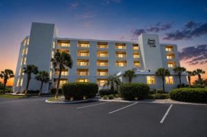 a hotel with a parking lot in front of it at Sands Beach Club in Myrtle Beach