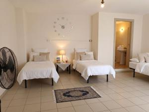 a room with two beds and a clock on the wall at SteLuRe in Aradeo