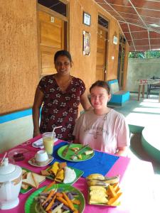a woman and a girl sitting at a table with food at Dilanya Homestay in Habarana +18 photos
